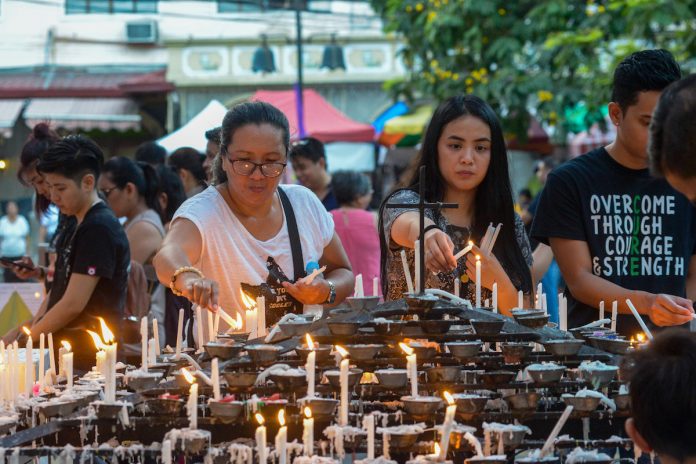Filipino faithful light candles outside a Church in Manila during a Holy Week ritual. During his time, Jesus attracted so many people to himself because he cared for those who were "dirty" and "unholy." (Photo by Maria Tan)
