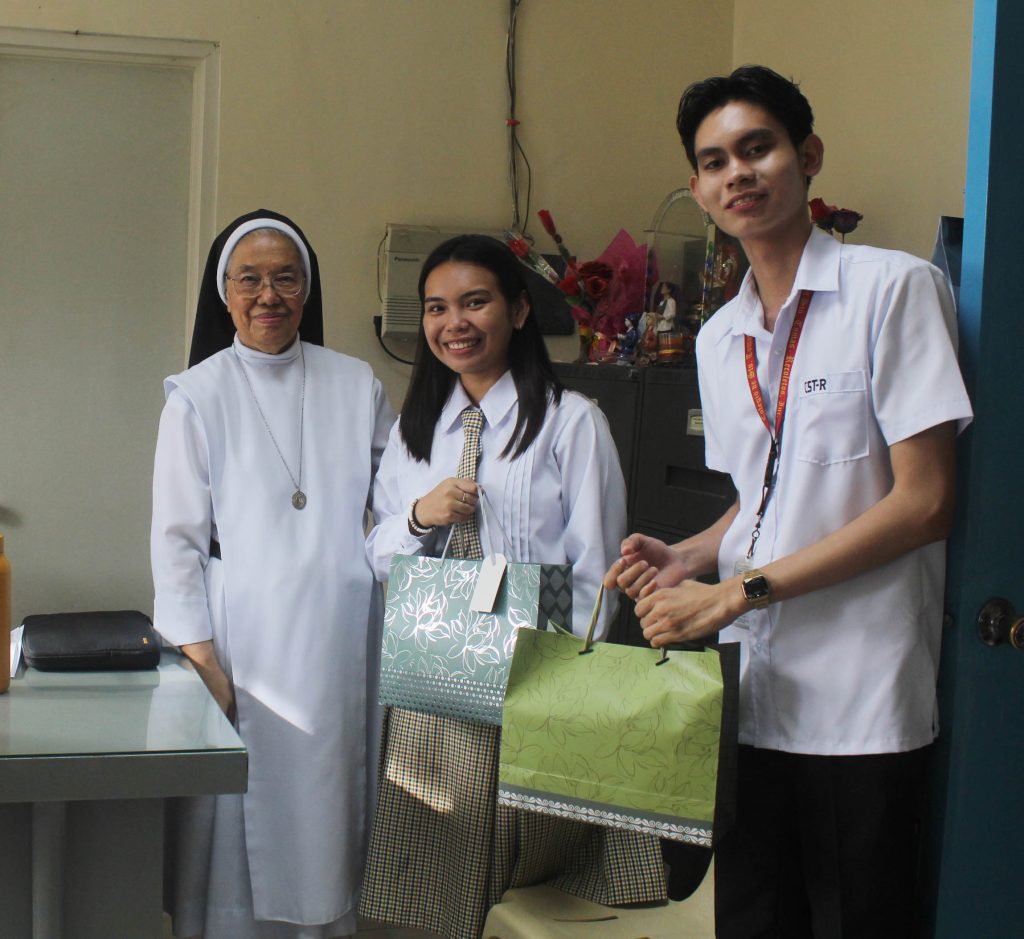 For the Working Scholars. Karl Osano, SSC president, and Julia Alfon, vice-president, turn over garments for the Ritarian working-scholars to Sr. Dela Cruz.